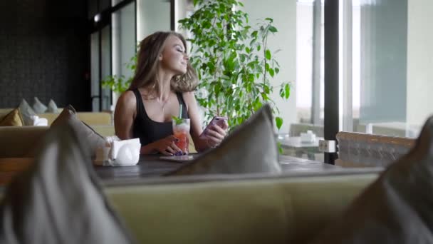 Portret pięknej dziewczyny Blondynka, siedząc w kawiarni w okresie letnim. — Wideo stockowe
