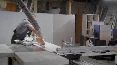 Endüstriyel marangoz işçilerin ahşap kesme makinesi üzerinde çalışma.