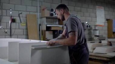 Atölye bir mobilya montaj üniformalı profesyonel sanayi işçisi.