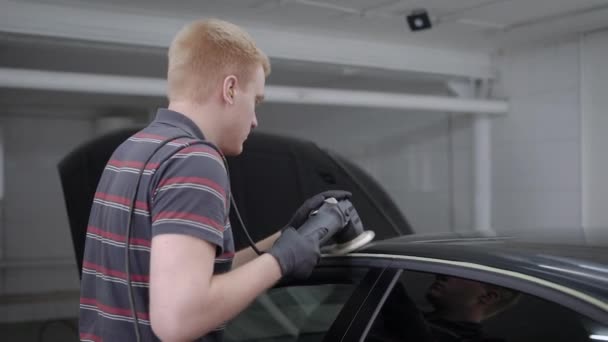 Manliga arbetstagare arbetar på polermaskin på biltvätt station. — Stockvideo