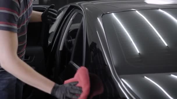 Чоловік шліфує двері автомобіля і дах після його миття . — стокове відео
