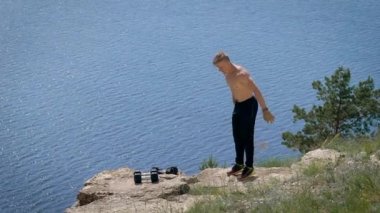 Yaz aylarında bir backflip tepede ağır çekimde yapan kaslı erkek.