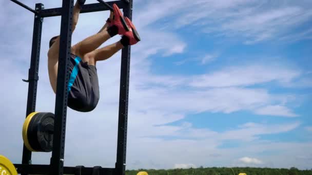 Athletische männliche Sportler trainieren draußen an speziellen Geräten. — Stockvideo