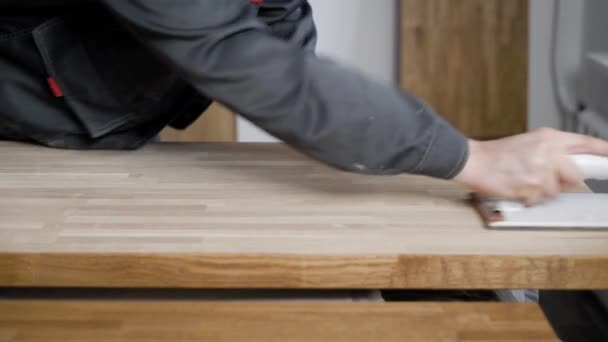 Carpenter is processing timber planks, grinding by abrasive paper, rubbing it over surface, close-up of hands — Stock Footage Carpenter is processing timber planks, grinding by abrasive paper, rubbing it over surface, close-up of hands Royalty Free Stock Footage