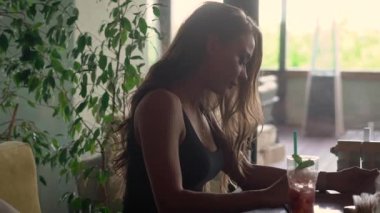 güzel kadın yaz günde bir kafede menüyü okuyan, masada oturan ve kamera hareketli sayfaları, saygısız