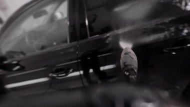 Çamaşır makinesi su üzerinde siyah bir otomobil kauçuk kılıfı, su jeti görünümü kullanarak bir oto yıkama içinde dökme