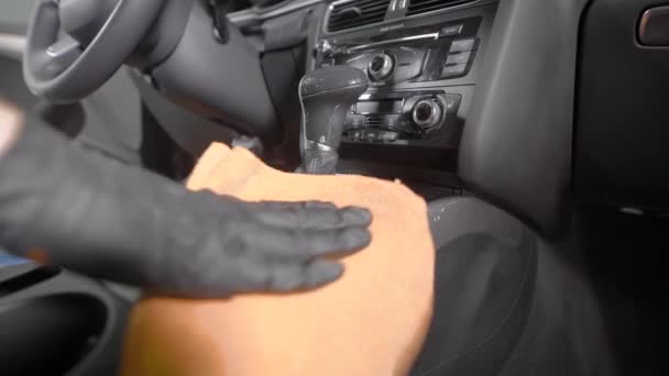 Trabalhador está limpando o punho da caixa de engrenagens e do painel de controle dentro do automóvel em um serviço de lavagem de carro — Vídeo de Stock