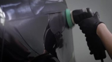 adam parlak elektrik polisaj makinesi, yakın çekim dönen siyah otomatik yüzey üzerinden yayılıyor