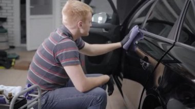 işçi lüks siyah araba kapılardan sonra işleme ve yakın oturan bir garajda yıkama koruyucu silme