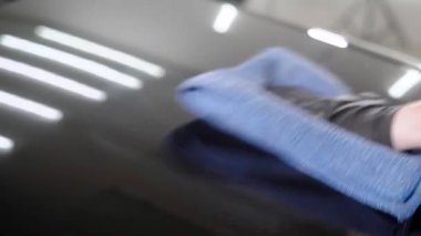 Mavi havlu ile araba örtünün parlatma adamın elini yakın çekim