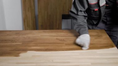 Adam ahşap panel boyasıyla el koyarak eldiven