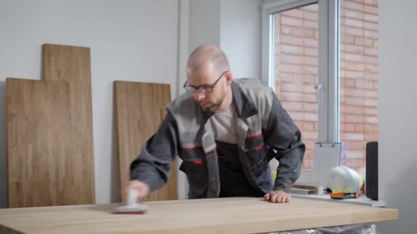 Man in glazen aanraken van houten plank in de kamer met panelen — Stockvideo