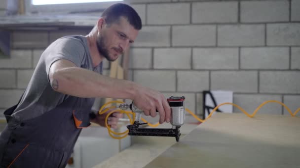 Hombre vistiendo uniforme trabajando con el perforador mientras hace agujeros en el panel — Vídeos de Stock