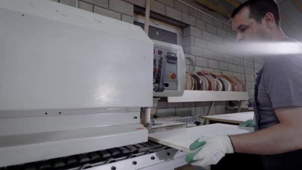 Промисловий столяр, що працює на кромці обв'язувальної машини на заводі . — стокове відео