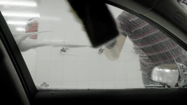 Працівник миє машину піною губкою — стокове відео