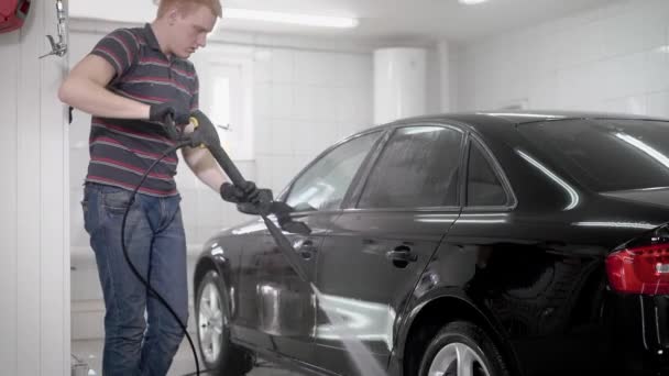 Travailleur utilise jer eau pour le lavage de voiture en lavage automatique  . — Video