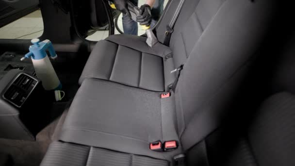 Empleado sin rostro cuidadosamente aspirando asiento de coche — Vídeos de Stock