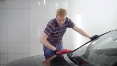 Kızıl saçlı erkek işçi tarafından koruyucu tabaka kaplama araba yüzey parlatma makine bir araba servisi tarafından işleme