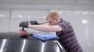 işçi onarımından sonra siyah araç oto servisi çatı yüzeyinin zımpara iş, elektrikli aracını kullanarak