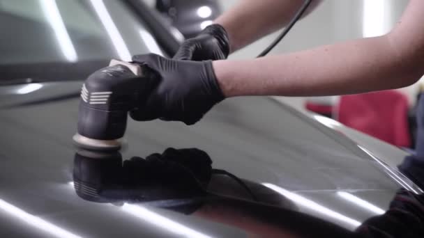 Close-up shot van een man die zwarte auto kap met behulp van speciale machine waxen. — Stockvideo