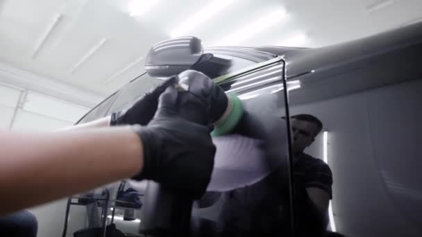 Trabajador está creando una cubierta protectora en el colorante del automóvil, frotando girando la máquina de molienda en auto-servicio — Vídeos de Stock