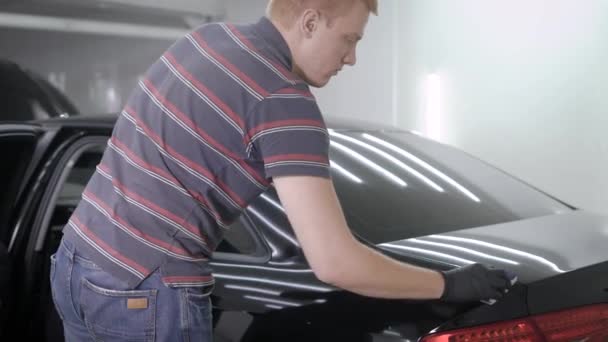 Hand att sätta spray samtidigt tar hand om bilen i garaget — Stockvideo