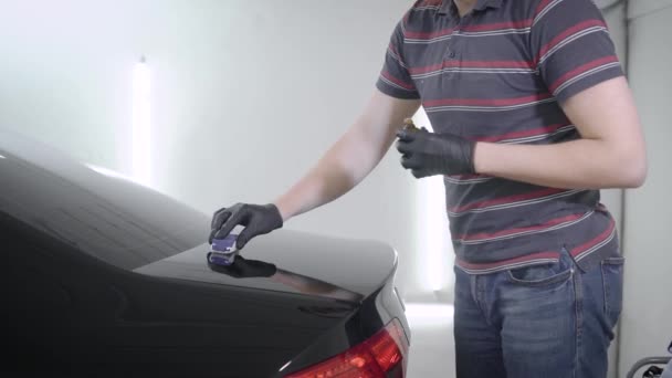 Puesta a mano spray mientras cuida de coche en el garaje — Vídeos de Stock