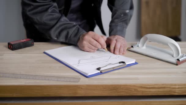 Foto ravvicinata del costruttore che fa schizzi di lavoro su carta . — Video Stock