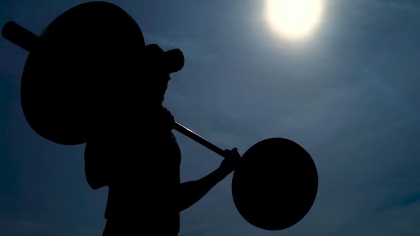Primer plano de una silueta de hombre haciendo ejercicio con barbell al aire libre . — Vídeos de Stock