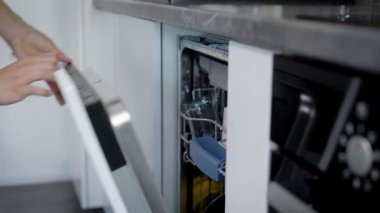 Mutlu genç kadın evde bulaşık makinesi levha düzenlenmesi