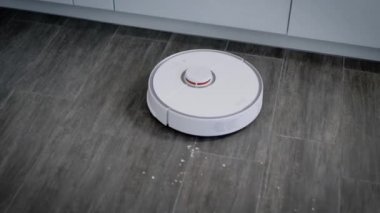 Modern robot elektrik süpürgesi ev mutfağında çalışıyor..