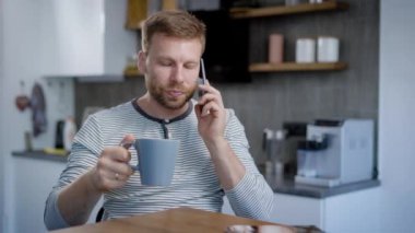 Bir adam mutfağında oturan ve Evet. Kahvaltı, kahve ve keyifli vakit geçirmek için arkadaşları ile sohbet.