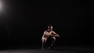 Atletik adam karanlıkta yerden atlama