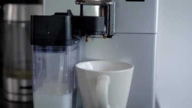 eve kahve makinesi sabah, dökme sıcak içecek bir fincan kapuçino mutfakta üretiyor