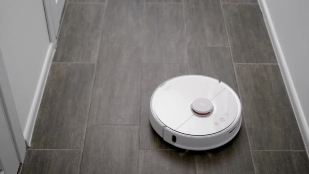 Ρομπότ καθαριστής κινείται πέρα από το πάτωμα σε ένα μοντέρνο διαμέρισμα, εργάζονται σε λειτουργία αυτο-κίνησης, καθαρισμός αυτόνομα — Αρχείο Βίντεο