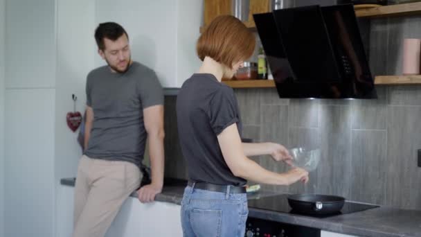 Mujer haciendo desayuno con el hombre en la cocina — Vídeos de Stock