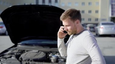 Adam arabasını park yerinde kırdıktan sonra autoservice içinde arıyor üzgün.