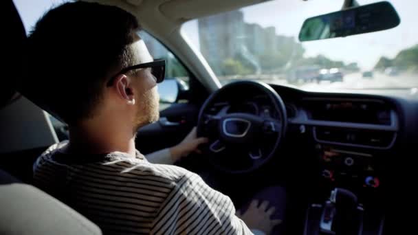 Vista desde el asiento trasero de un hombre conduciendo un coche de lujo con salón de cuero . — Vídeo de stock