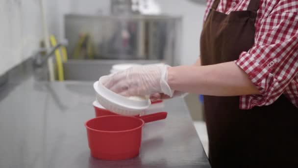 Plant worker shaping fresh cheese curd using plastic forming sieve. — Stock Video