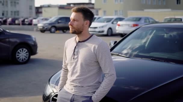 Mann steht entspannt neben Auto — Stockvideo