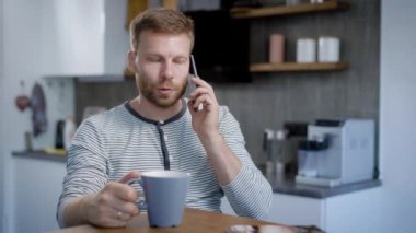 Smartphone'da kahvaltı sırasında konuşan adam