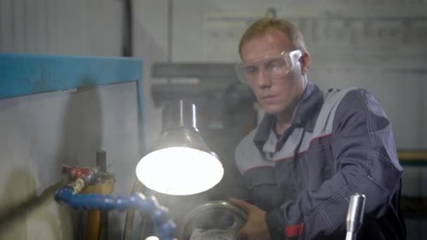 Un trabajador en la fábrica en la máquina. un hombre trabajando en un torno. Fabricación de herramientas — Vídeos de Stock