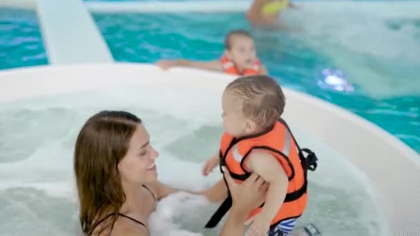 Мать и ребенок плавают в бассейне — стоковое видео