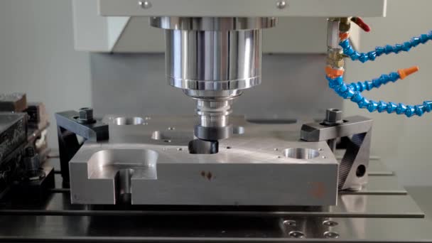 Zaagmachine snijdt gaten in een metalen detail in een fabriek werken Cnc toestellen, close-up — Stockvideo