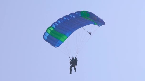 Параплан летит в небе ведущих навес на ремни, вид на спортсмена с земли, наклон вверх — стоковое видео