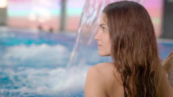 Koyu saçlı kız yalnız ve rahatlatıcı hidromasaj küveti yüzme havuzunda bir kase oturuyor — Stok video