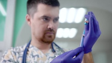 erkek doktor bir şırınga tarafından küçük cam şişe, uyuşturucu iğne bir klinikte hazırlanılıyor doluyor