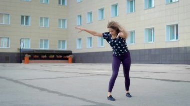 Genç kız çağdaş dans döne döne ve iplik yaz aylarında gündüz şehir sokakta gerçekleştiriyor