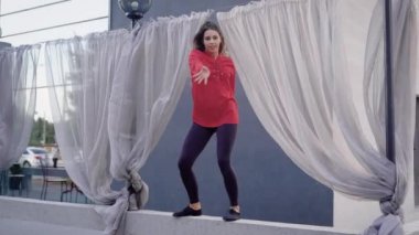 Genç ve ince sokak dansçısı kadın atlama ve çit dans bir sokakta gündüz de döne döne