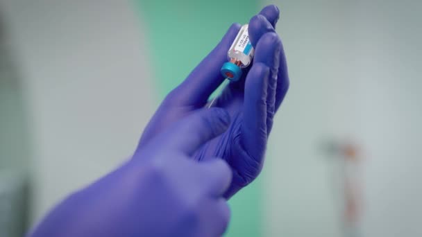 Ruce v modré gumové rukavice s injekční stříkačkou — Stock video
